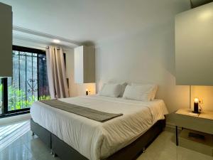 una camera con un grande letto e una finestra di Lalinde by Wynwood House a Medellín