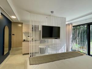 a living room with a television on a wall at Lalinde by Wynwood House in Medellín