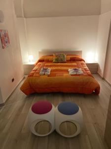een slaapkamer met een groot bed met 2 poeven bij Casuale House in Castel SantʼElia
