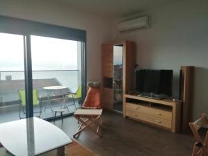 a living room with a television and a table with chairs at Apartmani Seaside in Dobra Voda