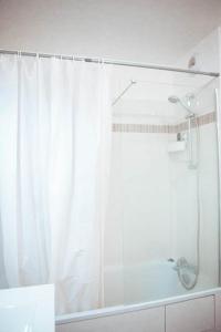 uma casa de banho com um chuveiro e uma cortina de chuveiro branca. em Colocation de Janvier à Fin Juin une chambre disponible em Linas