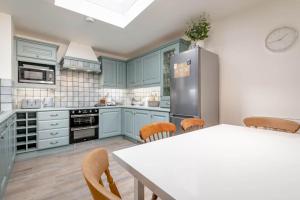a kitchen with blue cabinets and a table with chairs at Crail Town House in Crail