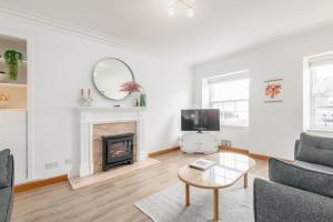 a living room with a fireplace and a tv at Crail Town House - Sleeps 6 in Crail