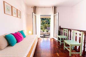 a living room with a couch and a balcony at A Casa da Tia in São Vicente