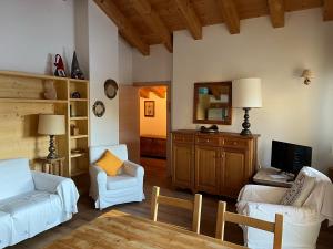 ein Wohnzimmer mit einem Sofa und 2 Stühlen in der Unterkunft Chalet delle Dolomiti in Pieve di Cadore
