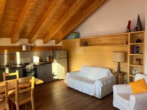 a living room with a table and a kitchen at Chalet delle Dolomiti in Pieve di Cadore
