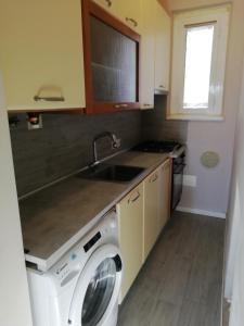 a kitchen with a washing machine and a sink at Delizioso trilocale Lodi città in Lodi