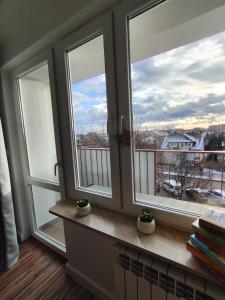- deux fenêtres dans une chambre avec vue sur un balcon dans l'établissement Apartament 6 osób Włodawa, à Włodawa