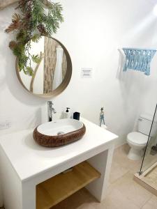 ein Badezimmer mit einem Waschbecken und einem Spiegel auf der Theke in der Unterkunft Xarraca in Bayahibe
