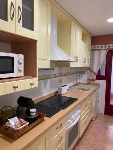 a kitchen with a microwave and a stove top oven at SUEÑOS DEL MAR in Motril