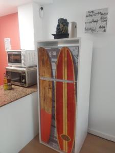 una nevera con tabla de surf en la cocina en la casita de salou, en Salou