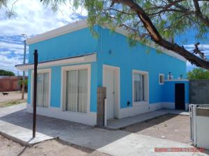 un edificio azul y blanco con un árbol en Complejo La Celeste en Playas Doradas