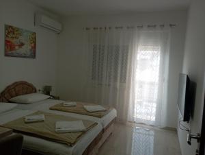 a white room with two beds and a window at Apartmani Marija in Vrdnik
