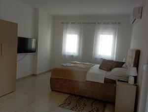 a bedroom with a large bed and a flat screen tv at Apartmani Marija in Vrdnik