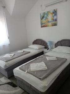 two beds in a room with towels on them at Apartmani Marija in Vrdnik