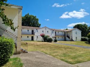 una fila de edificios blancos con un patio en Logement agréable proche Bordeaux en Pont-de-la-Maye
