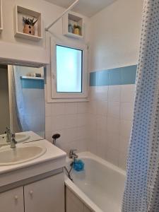 a bathroom with a sink and a bath tub at Logement agréable proche Bordeaux in Pont-de-la-Maye