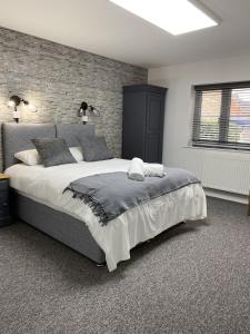 1 dormitorio con 1 cama grande y pared de ladrillo en The Roade House en Northampton