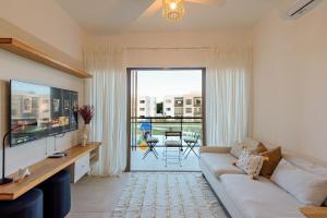 sala de estar con sofá y ventana grande en Apartamento 2 habitaciones piscina cerca de playa, en Punta Cana