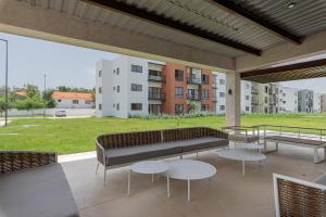 un patio con un banco y mesas y un edificio en Apartamento 2 habitaciones piscina cerca de playa, en Punta Cana