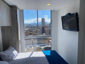 a bedroom with a view of a city from a window at Inside the heart of Bogota in Bogotá