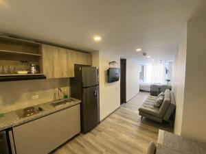 a kitchen with a refrigerator and a couch in a room at Inside the heart of Bogota in Bogotá