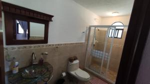 a bathroom with a toilet and a glass shower at Casa rústica de campo in Tecozautla