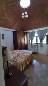 1 dormitorio con cama y lámpara de araña en Casa rústica de campo, en Tecozautla