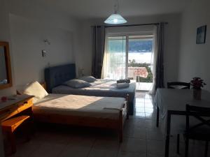 a bedroom with two beds and a window and a table at Geni Bay in Yénion
