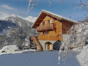 a log cabin in the snow with a car at Les Cabris in Pelvoux