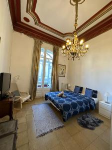 a bedroom with a blue bed and a chandelier at Barcelona Central Apartments in Barcelona