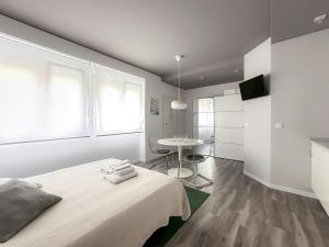 Dormitorio blanco con cama y mesa en Budget Inn en Valencia