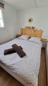a bedroom with a bed with a wooden headboard at La Casa De Lylou location de bungalows in Lavos