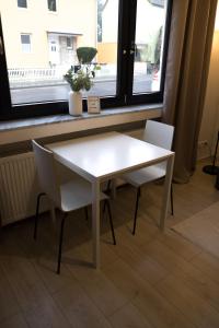 einen weißen Tisch und zwei Stühle vor einem Fenster in der Unterkunft FeWo Hübner in Andernach