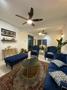 een woonkamer met blauwe banken en een plafondventilator bij IDAMAN HOMESTAY in Jasin