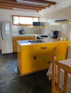 uma cozinha com um balcão amarelo e um frigorífico em Ohana em San Carlos de Bariloche