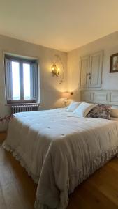 a large white bed in a bedroom with a window at Residenza Buggiano Antica B&B - Charme Apartment in Tuscany in Borgo a Buggiano