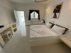 a bedroom with a large bed and a desk at Ascot Watamu in Watamu