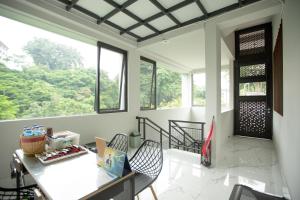 Habitación con mesa, sillas y ventanas. en My Stay Semarang, en Candi