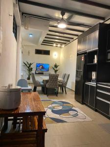 a living room with a table and a kitchen at IDAMAN HOMESTAY in Jasin