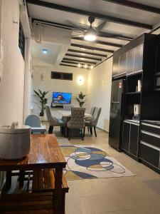 een woonkamer met een tafel en een keuken bij IDAMAN HOMESTAY in Jasin