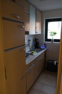eine Küche mit weißen Schränken, einem Waschbecken und einem Fenster in der Unterkunft FeWo Hübner in Andernach