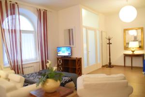uma sala de estar com um sofá e uma televisão em Loft in centro con parcheggio em Trieste