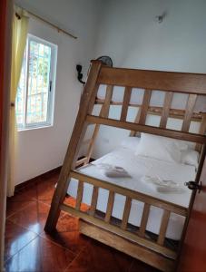 um beliche de madeira num quarto com uma janela em El santorini colombiano cabaña em Puerto Triunfo