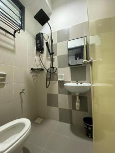 een badkamer met een wit toilet en een wastafel bij IDAMAN HOMESTAY in Jasin