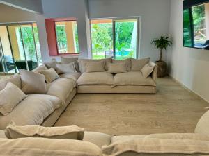 um sofá grande numa sala de estar com janelas em Sasay em Puerto Aventuras