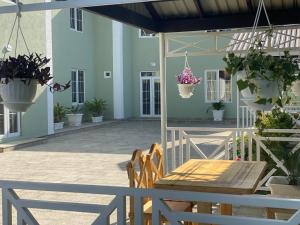 une terrasse avec une table, des chaises et des plantes en pot dans l'établissement Villa Yard, à Lankaran