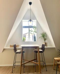 een tafel en stoelen in een kamer met een raam bij Hotspot 83 in Alkmaar