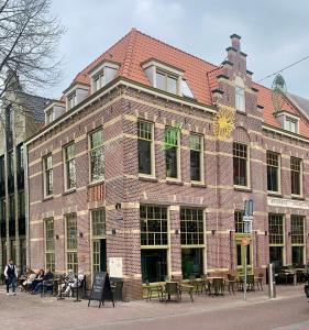 een groot bakstenen gebouw waar mensen buiten zitten bij Hotspot 83 in Alkmaar