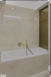 La salle de bains est pourvue d'une douche avec un robinet en or. dans l'établissement Luxury Wellness&Spa, à Bucarest